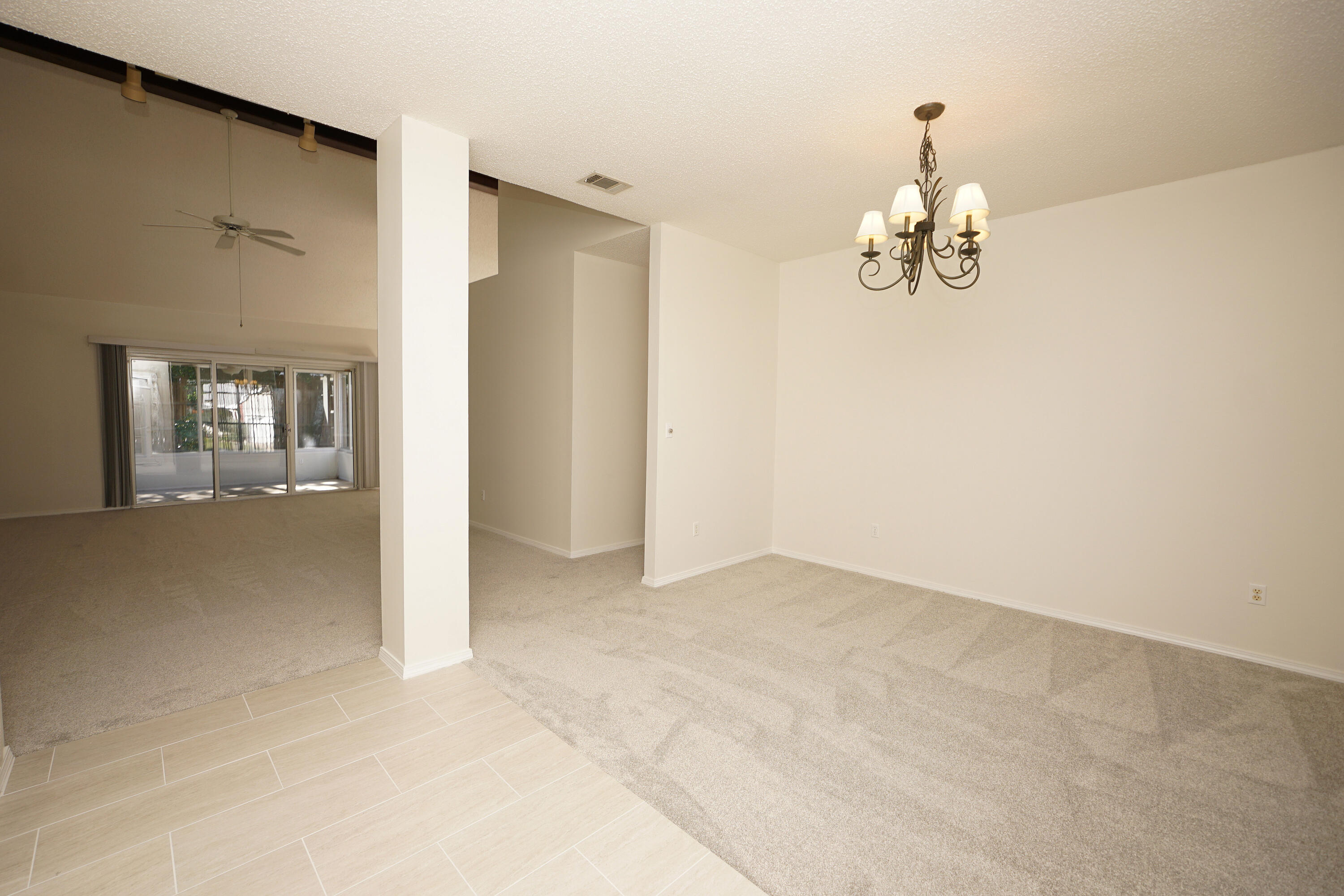 4505 Parkwood Square Niceville, FL 32578 - Photo 12 of 30 an empty room that has a chandelier fan and wooden floor