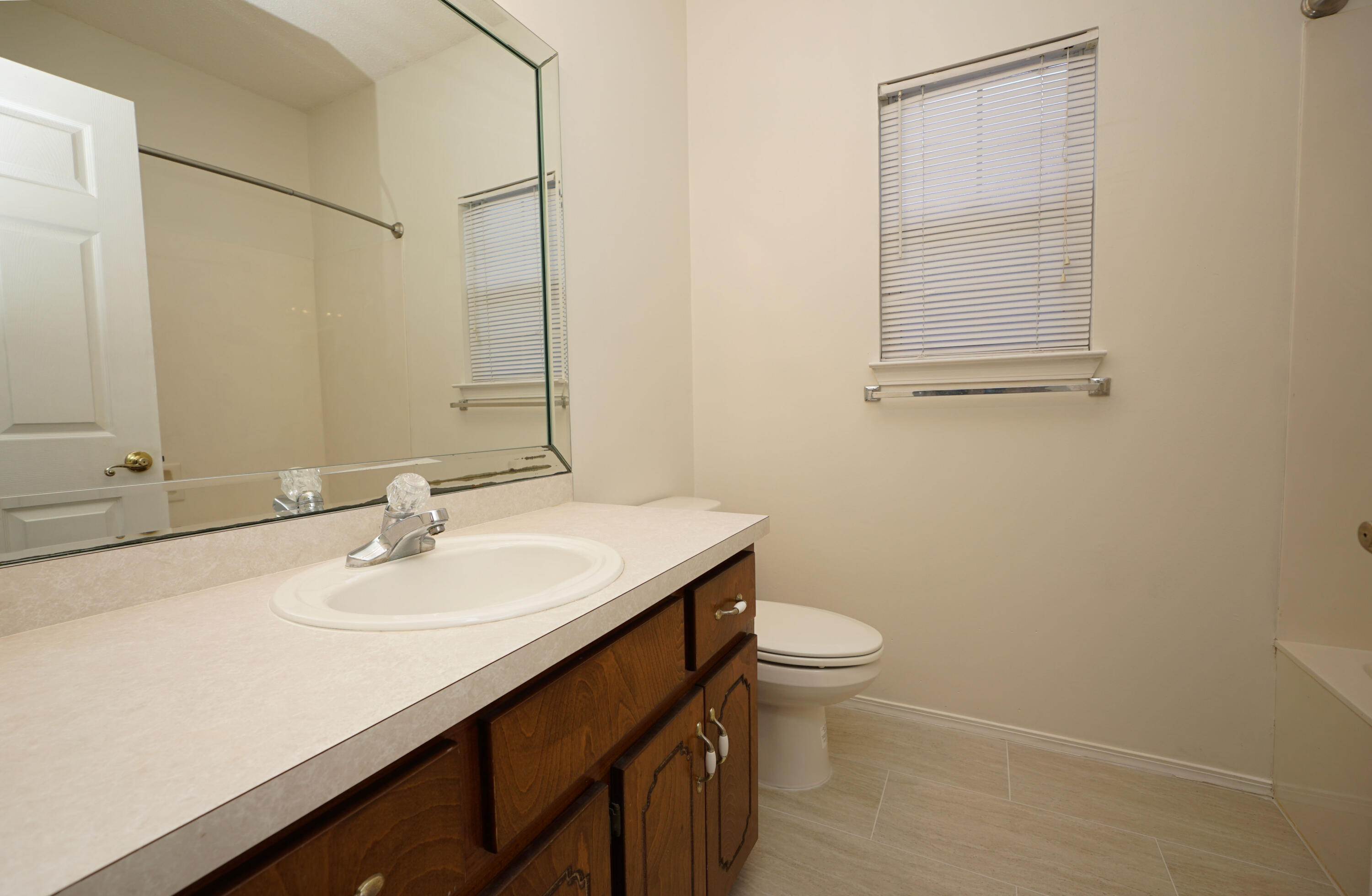 4505 Parkwood Square Niceville, FL 32578 - Photo 21 of 30 a bathroom with a sink a toilet and a mirror