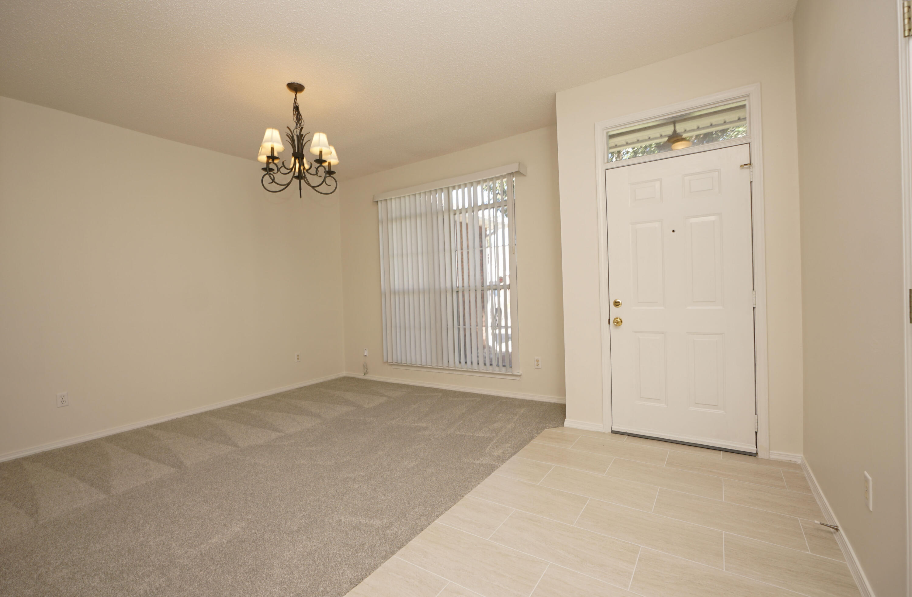 4505 Parkwood Square Niceville, FL 32578 - Photo 10 of 30 an empty room with chandelier and windows