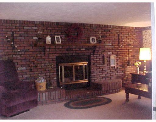 251 Ruth Street Plum, PA 15239 - Photo 4 of 8 Den/Family/Great Room. Full Wall Brick Woodburning Stove with heatolater Huge Wood Mantle and Brick seatingaccents WOW