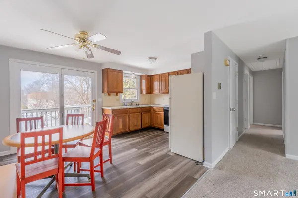 a kitchen with stainless steel appliances a stove a refrigerator a dining table and chairs