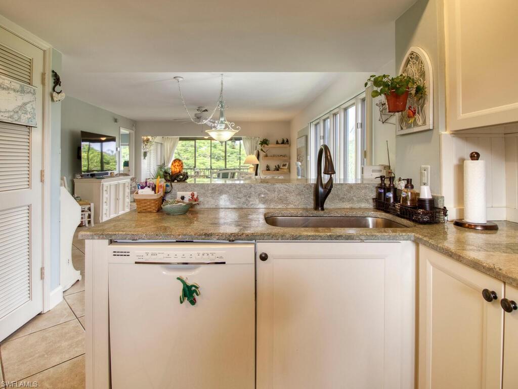 1633 Spoonbill Lane, Unit 1633C Naples, FL 34105 - Photo 11 of 35 a kitchen with stainless steel appliances granite countertop a sink and a refrigerator
