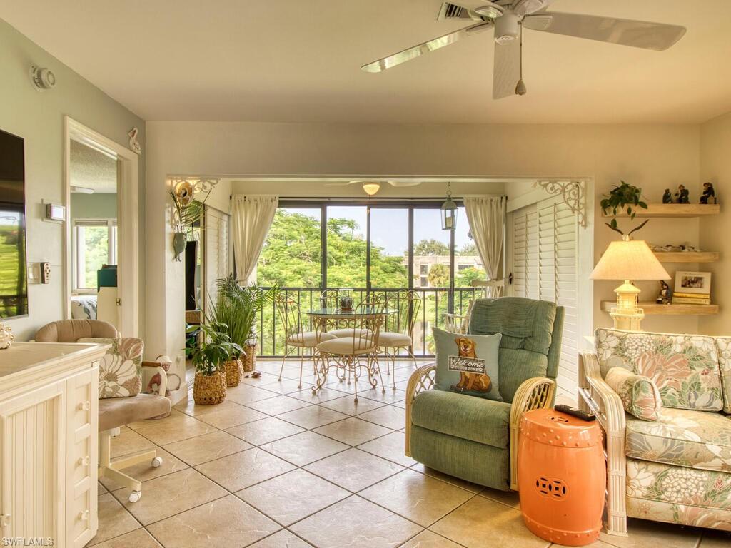 1633 Spoonbill Lane, Unit 1633C Naples, FL 34105 - Photo 13 of 35 a living room with furniture and a floor to ceiling window
