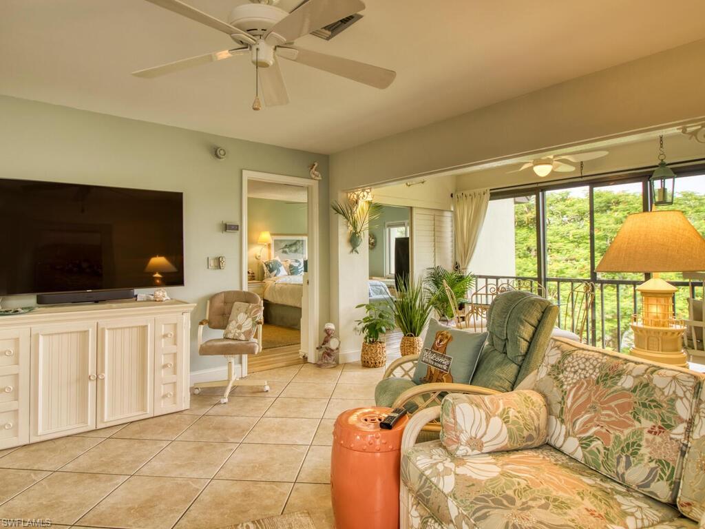 1633 Spoonbill Lane, Unit 1633C Naples, FL 34105 - Photo 14 of 35 a living room with furniture a flat screen tv and a large window