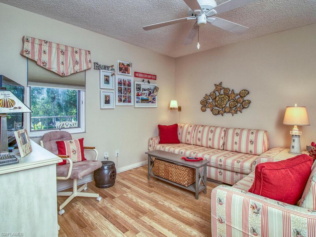 1633 Spoonbill Lane, Unit 1633C Naples, FL 34105 - Photo 17 of 35 a living room with furniture and a lamp