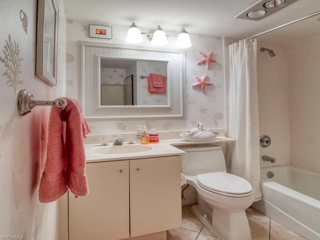 1633 Spoonbill Lane, Unit 1633C Naples, FL 34105 - Photo 19 of 35 a bathroom with a sink vanity mirror and toilet