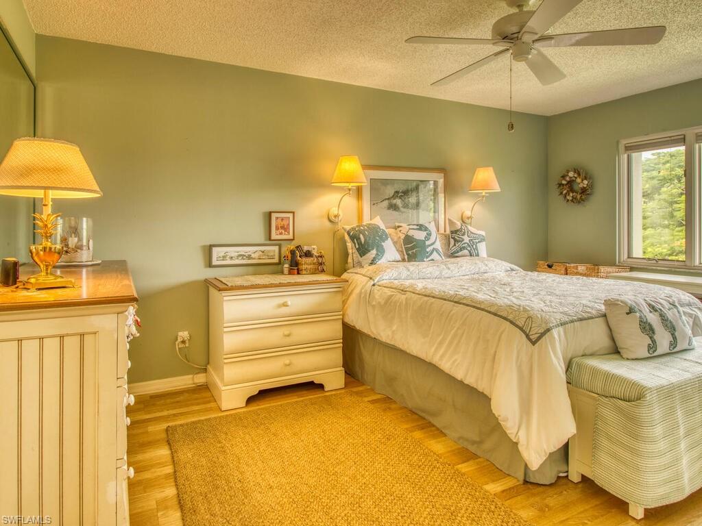 1633 Spoonbill Lane, Unit 1633C Naples, FL 34105 - Photo 21 of 35 a bedroom with a bed and a chandelier