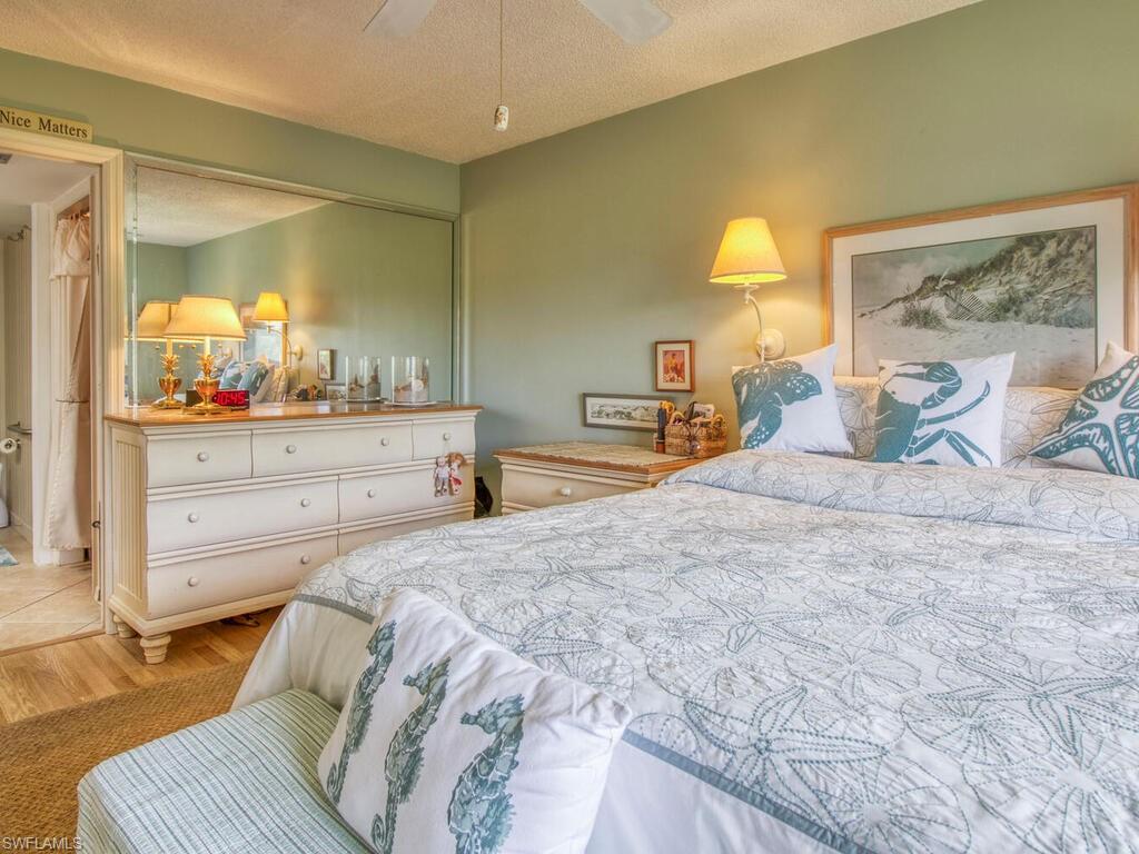 1633 Spoonbill Lane, Unit 1633C Naples, FL 34105 - Photo 22 of 35 a bedroom with a bed and a mirror