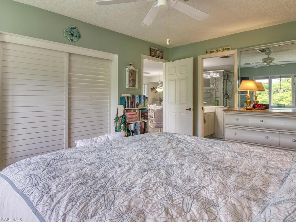 1633 Spoonbill Lane, Unit 1633C Naples, FL 34105 - Photo 23 of 35 a bedroom with a large bed and a large window