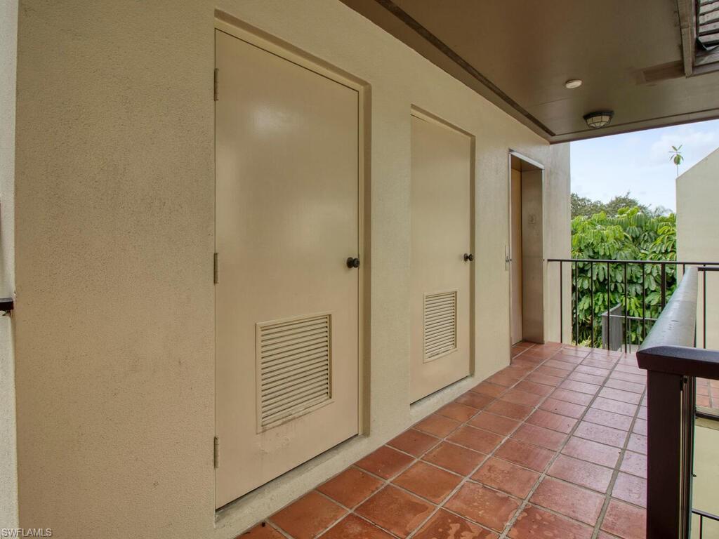 1633 Spoonbill Lane, Unit 1633C Naples, FL 34105 - Photo 26 of 35 a view of a porch with a door and wooden floor