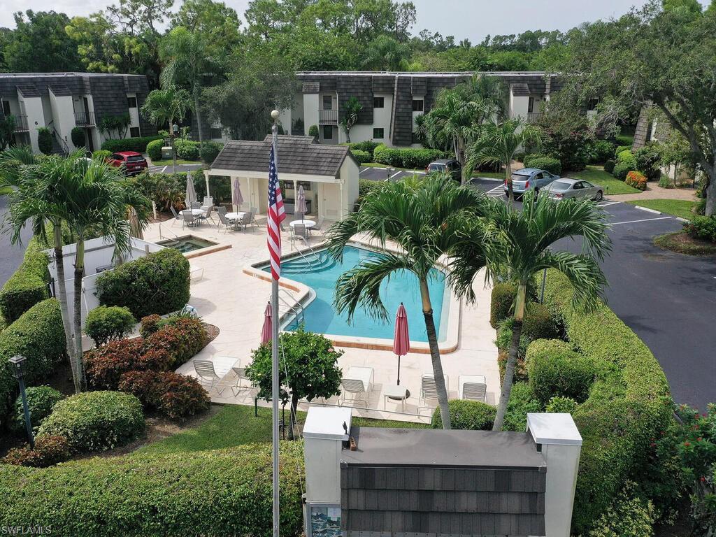 1633 Spoonbill Lane, Unit 1633C Naples, FL 34105 - Photo 27 of 35 a view of house with swimming pool and outdoor seating