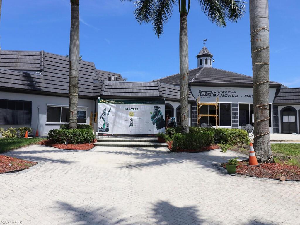 1633 Spoonbill Lane, Unit 1633C Naples, FL 34105 - Photo 31 of 35 a front view of a house with a yard and potted plants