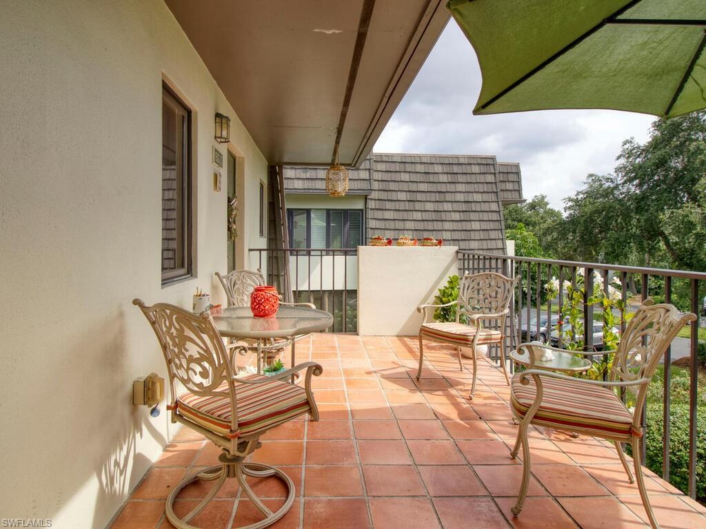 1633 Spoonbill Lane, Unit 1633C Naples, FL 34105 - Photo 5 of 35 a balcony with table and chairs