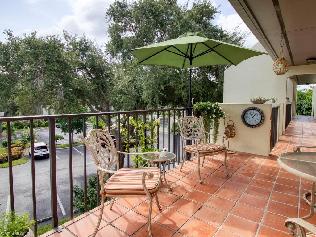 1633 Spoonbill Lane, Unit 1633C Naples, FL 34105 - Photo 6 of 35 a view of a chairs and table in the balcony