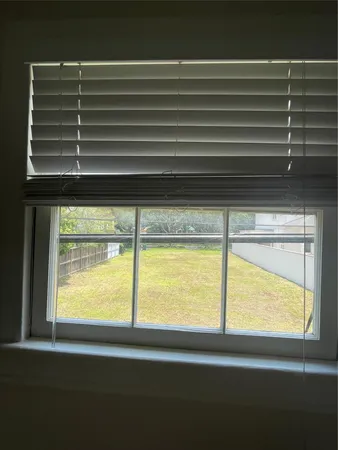 an empty room with wooden floor chandelier and windows