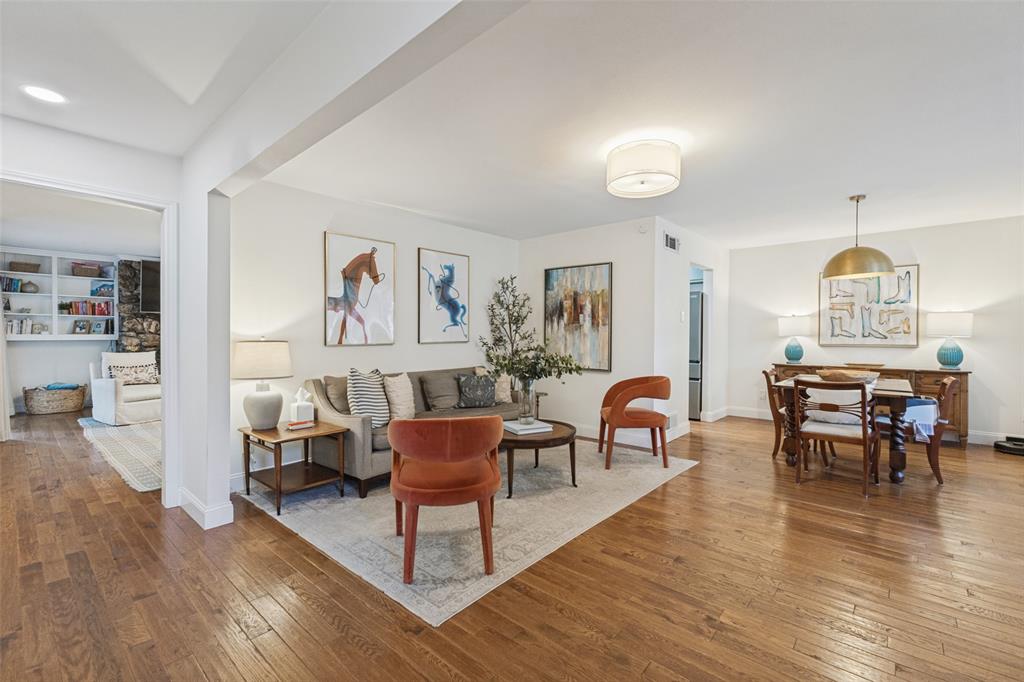 Hardwood flooring throughout, recessed lighting, built-in shelving, and a decorative fireplace