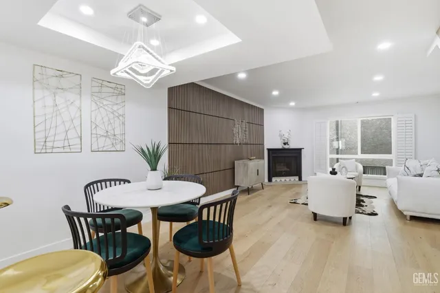 a view of a dining room with furniture a chandelier and wooden floor