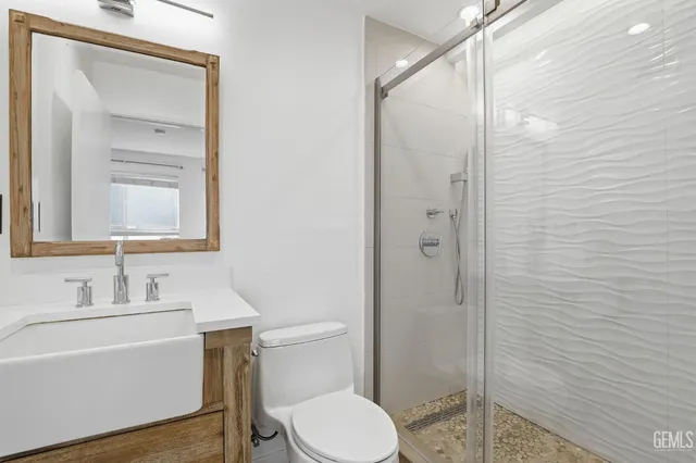 a bathroom with a toilet a sink a shower and vanity