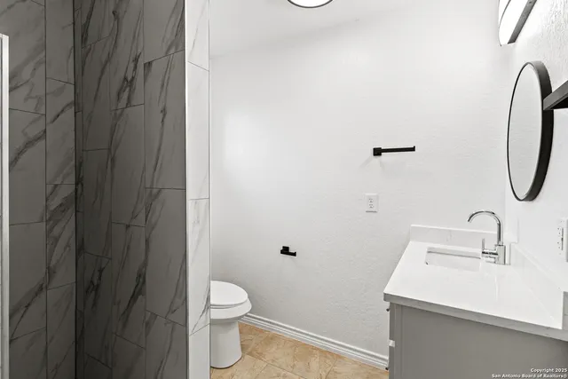 a bathroom with a sink a toilet and shower