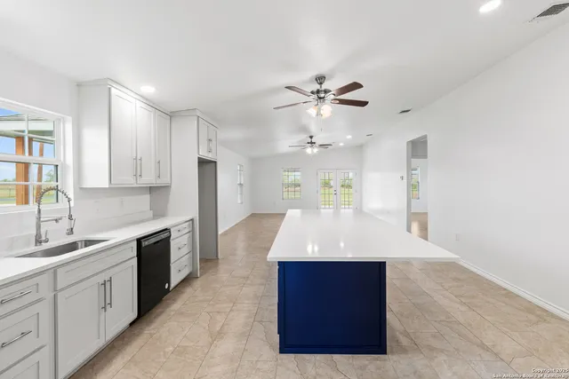 a large kitchen with kitchen island a sink stainless steel appliances and cabinets