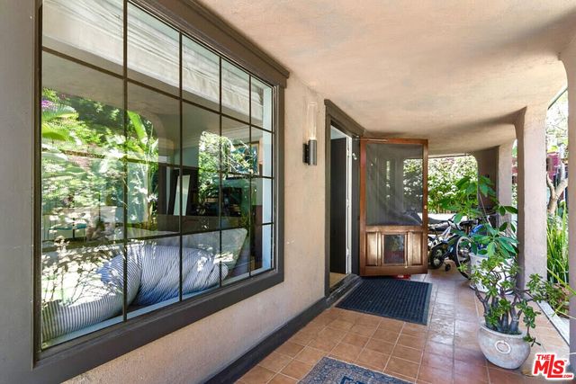 a view of a porch with chairs and potted plants