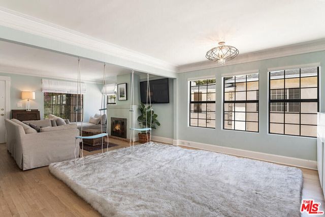 a living room with furniture large window and flat screen tv