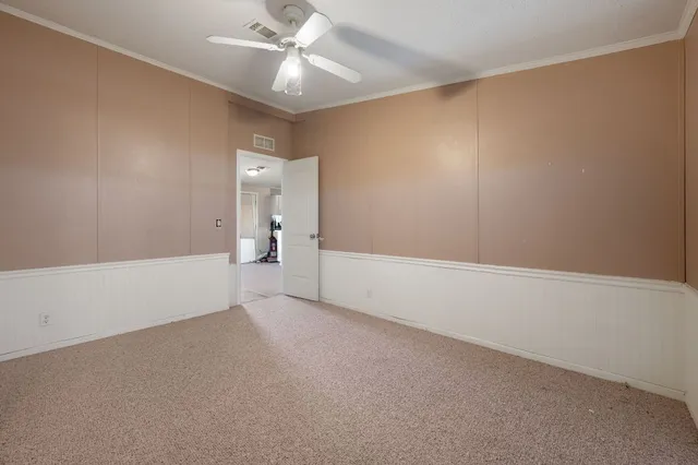 an empty room with a ceiling fan and a window