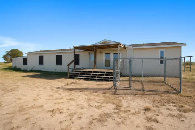 a view of a house with wooden fence