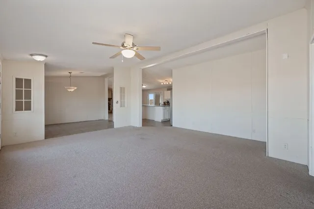 a view of a big room with chandelier fan and windows