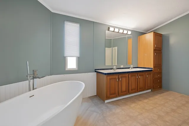 a bathroom with a tub a sink and mirror