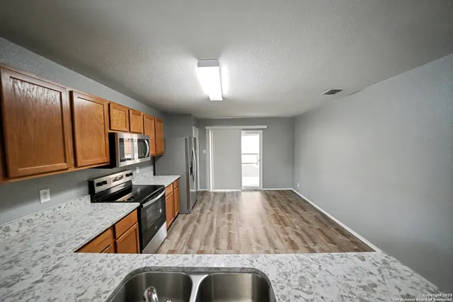 a kitchen view with wooden floor and a sink