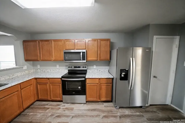 a kitchen with stainless steel appliances granite countertop a refrigerator stove and sink