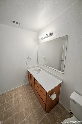 a bathroom with a sink toilet and mirror