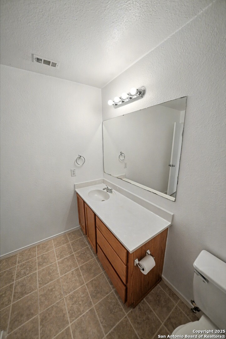 3615 Longhorn Creek San Antonio, TX 78261 - Photo 28 of 42 a bathroom with a sink toilet and mirror