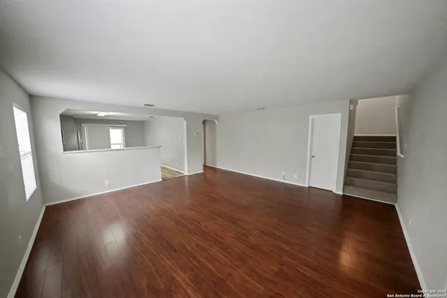 a view of wooden floor and windows in an empty room