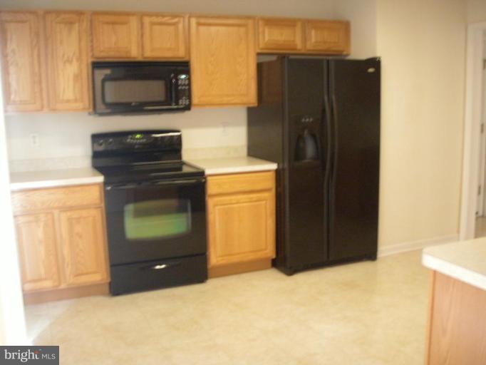 117 Hess Road Grasonville, MD 21638 - Photo 6 of 9 a kitchen with stainless steel appliances granite countertop a refrigerator and a stove top oven