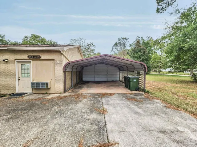 a view of a house with a yard and a large tree