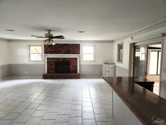 an empty room with windows and fireplace