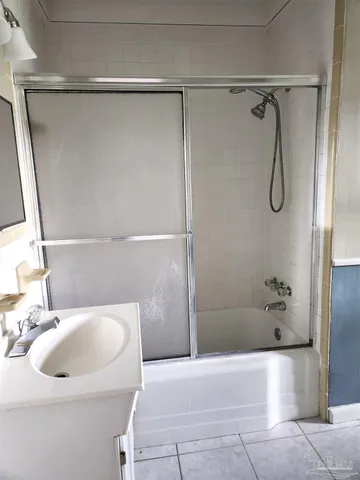 a bathroom with a granite countertop sink a toilet and shower