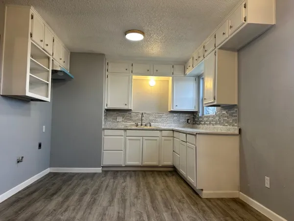 a bathroom with granite countertop a sink and a mirror