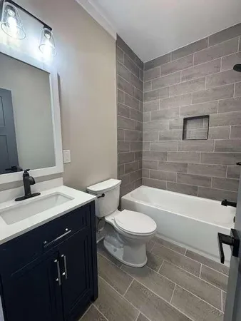 a bathroom with a sink a toilet a mirror and bathtub