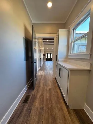a hallway with wooden floor closet and livingroom