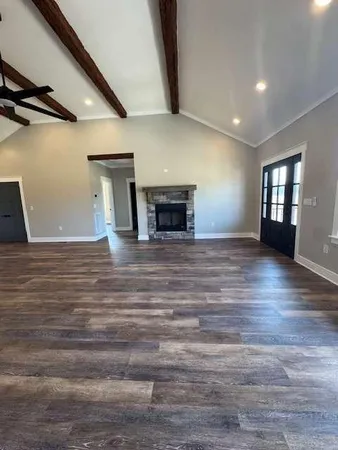 a view of a livingroom with wooden floor and a fireplace