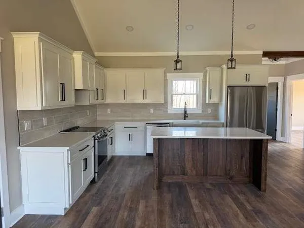 a kitchen with a sink a stove refrigerator and cabinets