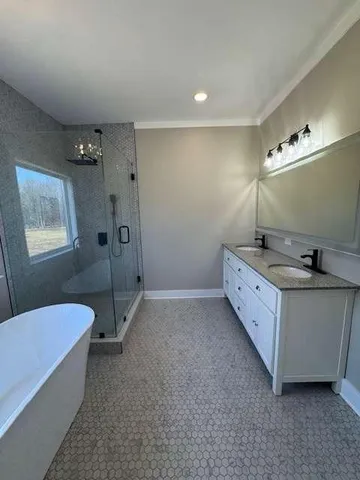 a spacious bathroom with a double vanity sink a mirror and a bathtub