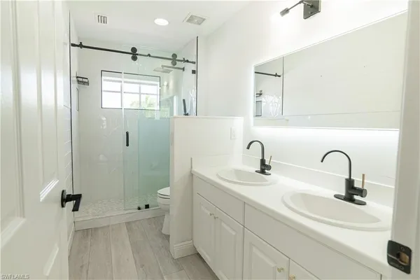 an aerial view of residential houses with outdoor space and trees