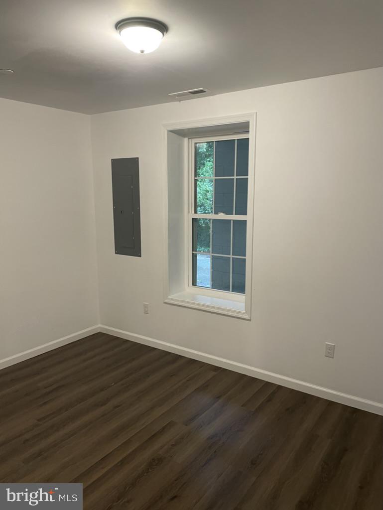 300 Collins Avenue, Unit 3 Hurlock, MD 21643 - Photo 9 of 13 a view of an empty room with wooden floor and a window