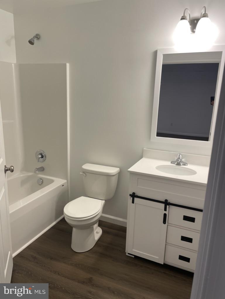 300 Collins Avenue, Unit 3 Hurlock, MD 21643 - Photo 10 of 13 a bathroom with a sink toilet a vanity and bathtub