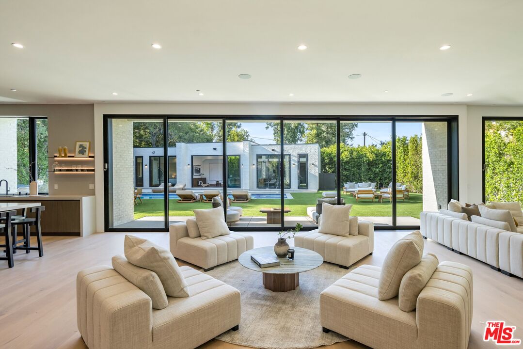 17055 Rancho Street Encino, CA 91316 - Photo 28 of 73 a living room with furniture and floor to ceiling windows
