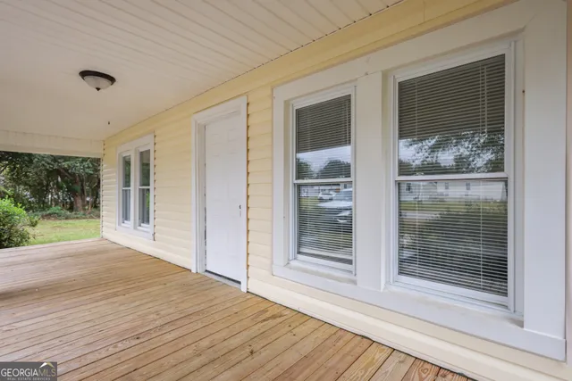a view of outdoor space with wooden floor and windows